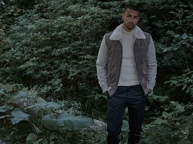 Emiliano Zapata campaign: a model in a shearling-collar jacket standing in dense greenery